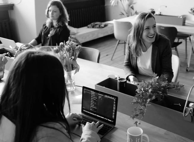 Three women sitting at desk collaborating